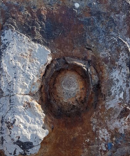 Stahlpfeiler, verrostet mit markanter runder Einkerbung und Farbresten. Fotodruck auf Dibond in diversen Formaten