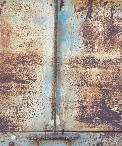 Stahltür mit blauen Farbresten. Schweißnaht, Rostmarken und Türscharnier. Fotodruck auf Dibond oder Forex in verschiedenen Formaten.