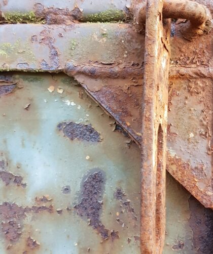Stahltür, blau - grau mit Schweißnähten, flächigen Rostmarken und Türriegel. Fotodruck auf Dibond oder Forex in verschiedenen Formaten.