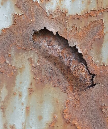 Stahltür mit Teilresten Farbe, Löchern und flächigen Rostmarken. Fotodruck auf Dibond oder Forex in verschiedenen Formaten.