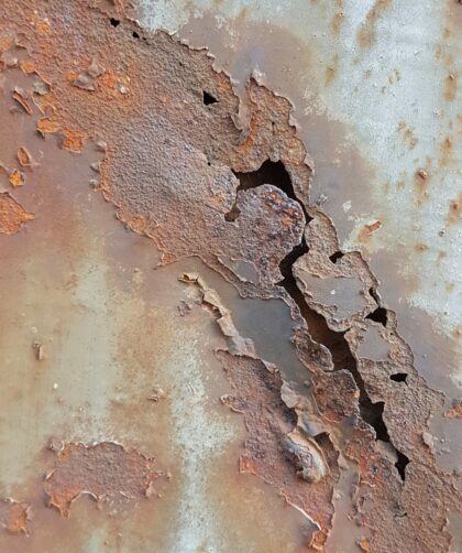 Stahltür mit Teilresten Farbe, Löchern und flächigen Rostmarken. Fotodruck auf Dibond oder Forex in verschiedenen Formaten.