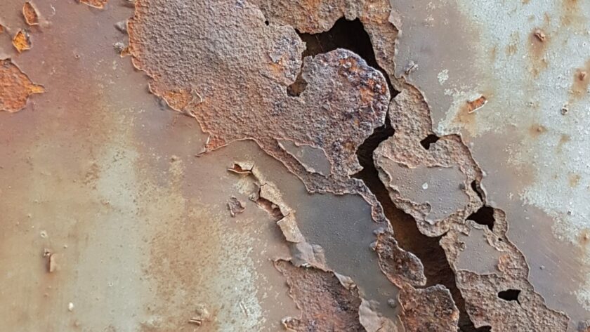 Stahltür mit Teilresten Farbe, Löchern und flächigen Rostmarken. Fotodruck auf Dibond oder Forex in verschiedenen Formaten.