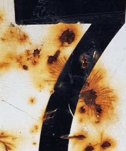 Pariser Stahlplatte, weiß mit schwarzer No. 7 und Rostmarken. Fotodruck auf Dibond oder Forex in verschiedenen Formaten.