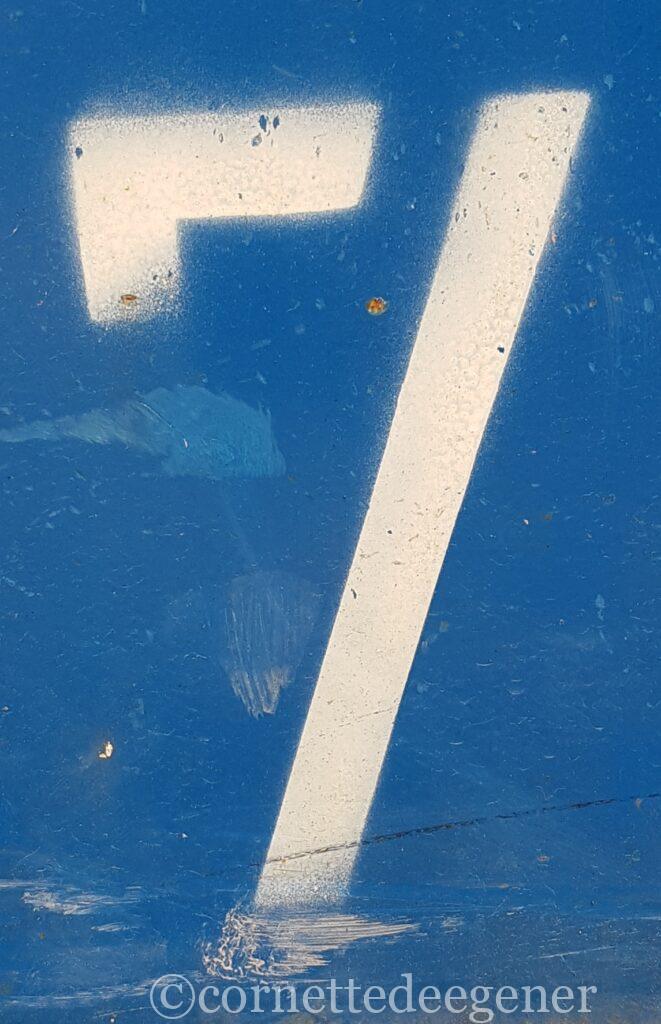 blaue Stahlplatte mit leichten Rostmarken und weisser No.7